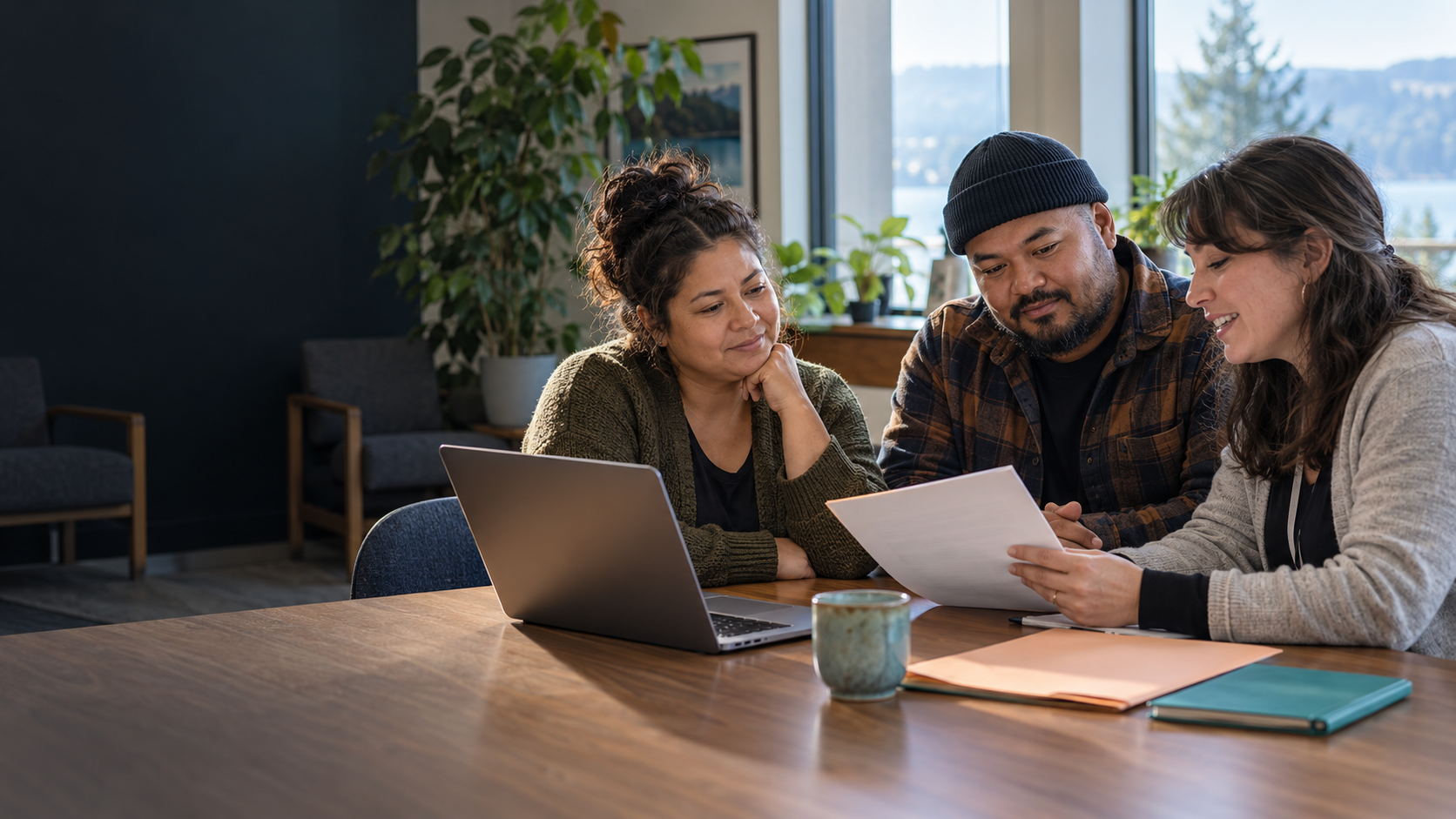 Three adults reviewing a direct-to-provider youth sponsorship request in a community office.